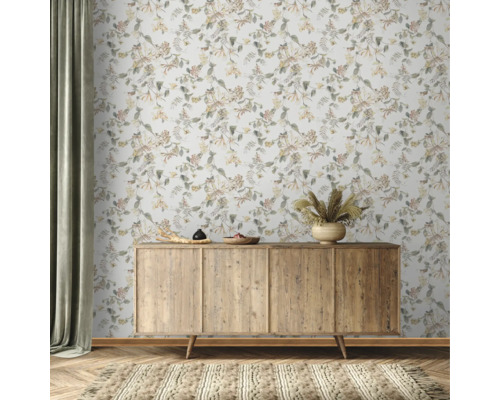 Scène avec un buffet en bois devant un papier peint floral et un tapis.