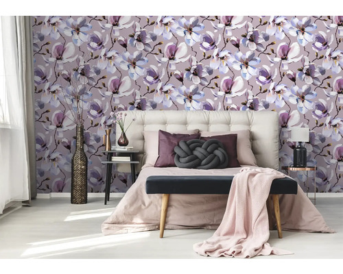 Chambre avec papier peint à motifs de fleurs de magnolia, lit et tables de chevet.