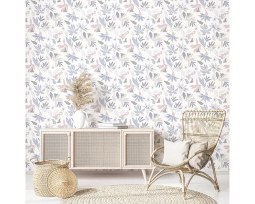 Salon avec papier peint floral, buffet, fauteuil en rotin et tapis rond