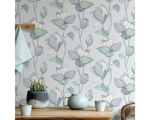 Papier peint fleuri avec théière et plante en pot sur table en bois