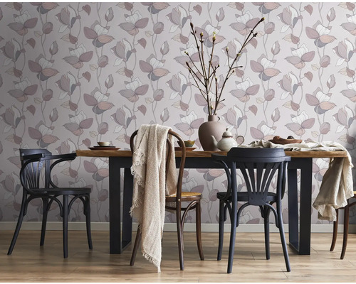 Salle à manger avec papier peint fleuri, table en bois et chaises.