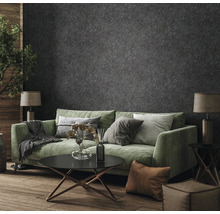 Salon avec canapé vert, table basse et papier peint à motifs