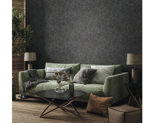 Salon avec canapé vert, table basse et papier peint à motifs