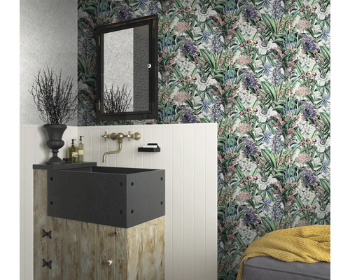Une salle de bain avec du papier peint floral, un lavabo sur un socle en bois et un miroir