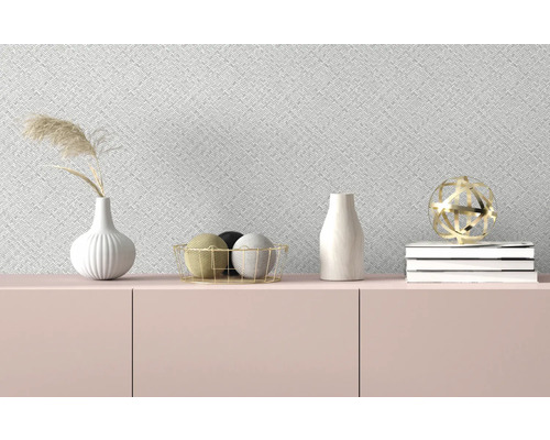 Objets décoratifs sur un buffet devant un papier peint à motifs