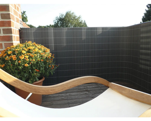 Balkonsichtschutz mit orangefarbener Chrysantheme im Topf auf Holzboden