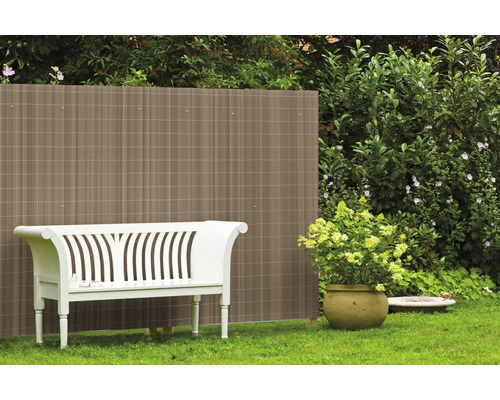 Gartenszene mit Sichtschutzzaun, weisser Bank und Topfpflanze