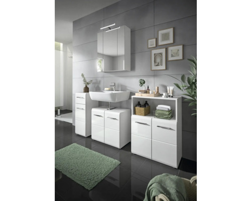 Salle de bains avec lavabo blanc, armoire de toilette et meubles bas assortis.