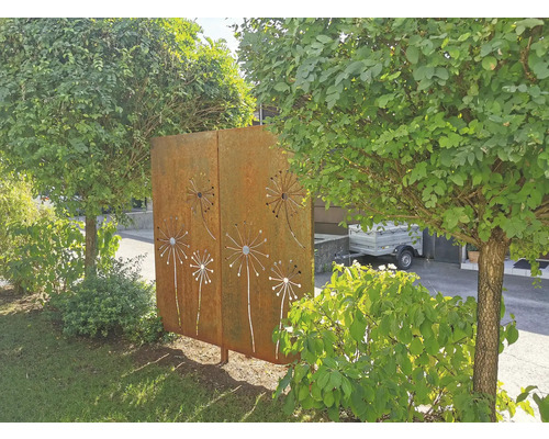 Dekorative Gartenelemente aus Metall mit ausgeschnittenen Pusteblumenmotiven zwischen Bäumen und Sträuchern.