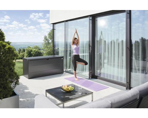 Terrasse avec coffre de rangement, table et femme faisant du yoga