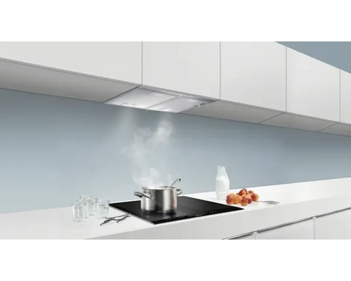 Scène de cuisine avec hotte aspirante au-dessus de la plaque de cuisson avec casserole