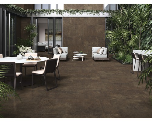 Terrasse avec carreaux de céramique bruns, mobilier de jardin et végétation luxuriante