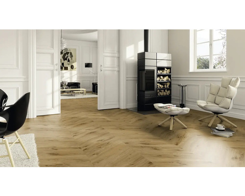 Salon avec parquet, cheminée et fauteuils.