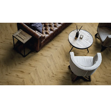 Salon avec sol stratifié à chevrons, canapé en cuir et fauteuils.