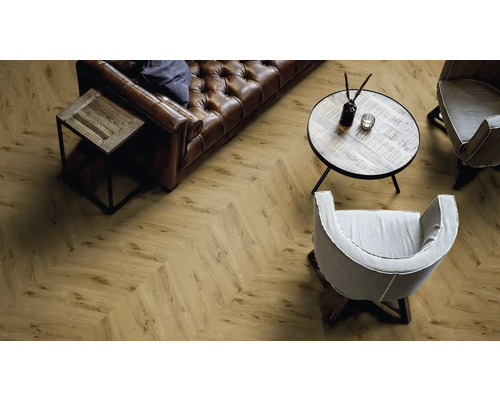 Salon avec sol stratifié à chevrons, canapé en cuir et fauteuils.