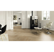 Salon lumineux avec parquet à chevrons, poêle et fauteuils