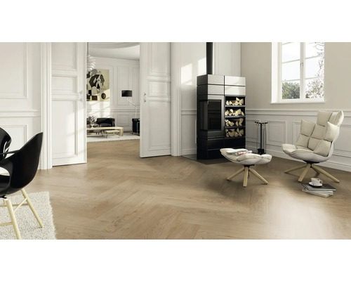 Heller Wohnraum mit Fischgrätparkett, Kaminofen und Sesseln