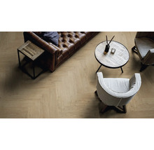 Salon avec canapé en cuir marron, table basse, table d''appoint et sol posé en motif à chevrons.