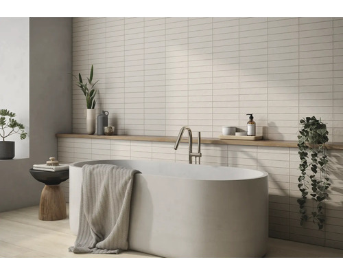 Salle de bains avec baignoire, robinetterie, serviette, étagère et carreaux muraux