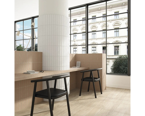 Pièce claire et organisée avec mur et sol carrelés, bureau et chaises