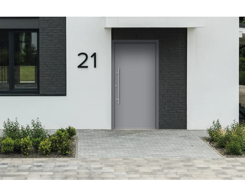 Haustür in modernem Design mit Hausnummer und gepflastertem Eingangsbereich