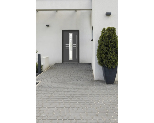 Graue Haustür mit Glaseinsatz in einer modernen Hausfassade mit Pflastersteinen
