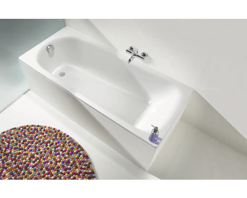 Rechteckige Badewanne mit Armatur und farbigem Teppich im Badezimmer