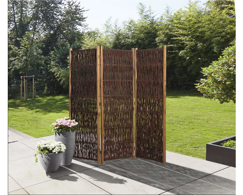 Scène de jardin avec un paravent en saule en trois parties et deux pots de fleurs plantés