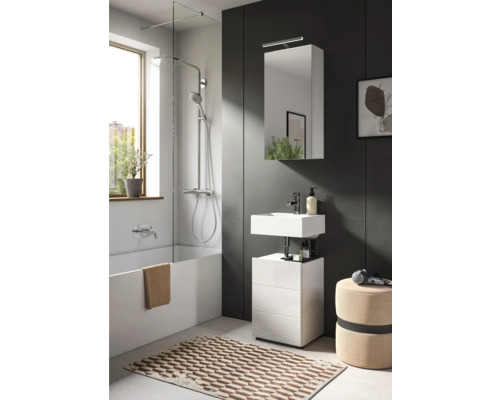 Badezimmer mit Badewanne, Duschabtrennung, Waschtisch, Spiegelschrank und Badteppich