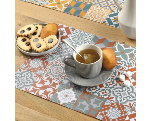 Tischläufer mit Fliesenmuster, Tasse Tee und Gebäck auf einem Tisch
