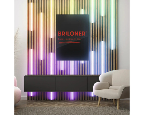 Wohnzimmer mit Lowboard, Sessel und farbiger Wandbeleuchtung