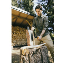 Homme fendant du bois avec une hache à fendre sur un billot à l''extérieur.