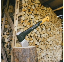 Hache sur une souche devant une pile de bois