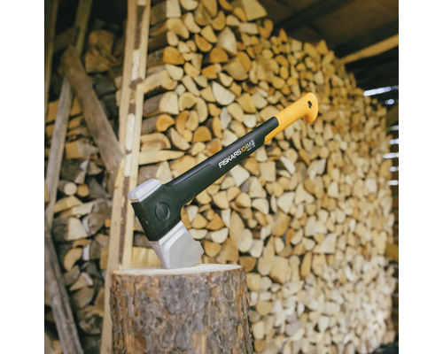Hache sur une souche devant une pile de bois