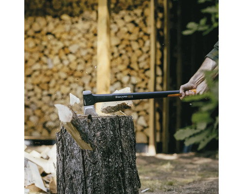 Hache à fendre Fiskars coupant du bois sur un billot