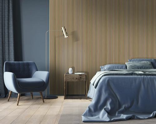 Chambre avec panneaux acoustiques, lit, fauteuil et lampadaire