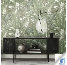 Un salon avec une console noire et un mur avec du papier peint floral.