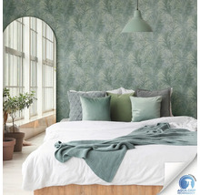 Chambre avec lit devant un mur orné de motifs de palmiers