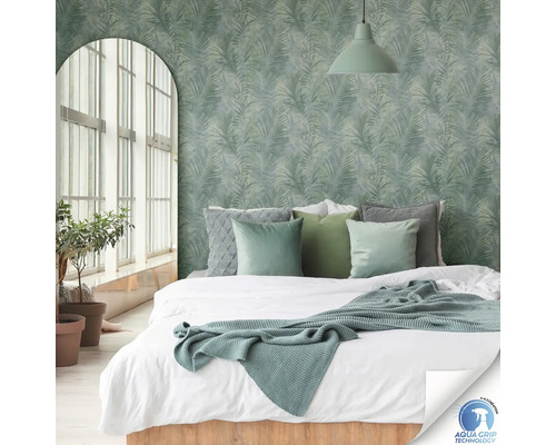 Chambre avec lit devant un mur orné de motifs de palmiers