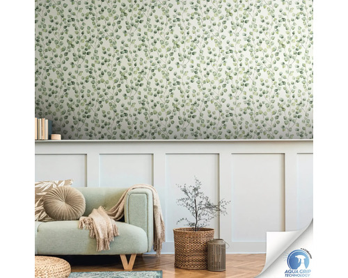 Salon avec papier peint à motif d''eucalyptus, canapé et plante dans un panier