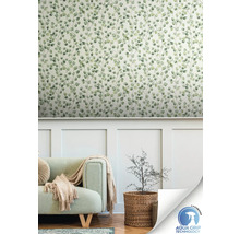 Salon avec un mur avec du papier peint à motifs de feuilles, un canapé et une plante dans un panier