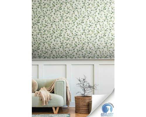 Salon avec un mur avec du papier peint à motifs de feuilles, un canapé et une plante dans un panier