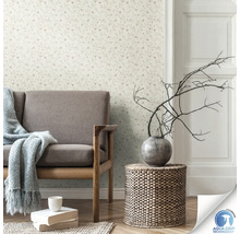 Salon avec papier peint à motifs floraux, canapé, table en bois et décoration