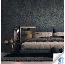 Chambre avec papier peint à motifs, lit, table de chevet et lampe