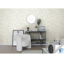 Salon avec papier peint à motifs floraux, fauteuil et décoration