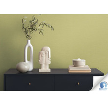 Gros plan d''une commode avec décoration et papier peint vert