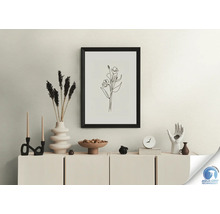 Nature morte décorative avec cadre, fleurs séchées, bougies et figurines sur une armoire.