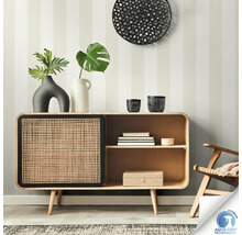 Buffet en bois avec porte en rotin devant un mur rayé