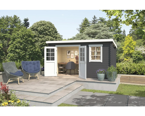 Jardin avec cabanon de jardin moderne avec fenêtre et double porte ouverte, mobilier de bureau, deux fauteuils en rotin avec coussins et plantations