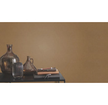 Vases décoratifs en verre et carnets sur une table devant un mur